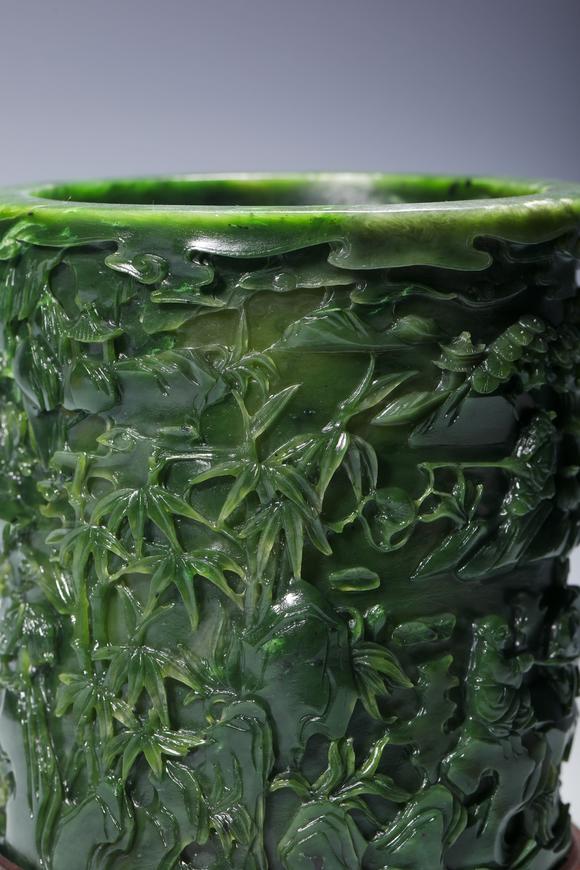 SEAVIEW AUCTIONS PTY LTDA Spinach Green Jade Cylindrical Brush Pot Carved with Mountain and Scholar Landscape, Wood Stand, China, 18th century
