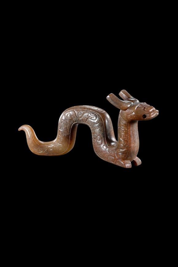 Castle AuctionA Calcified Brown Jade Dragon Pendant, Han, Circa 2nd C BC–2nd C AD Pr.