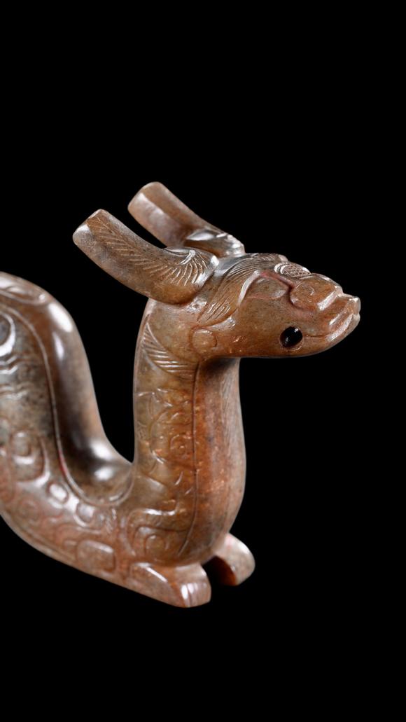 Castle AuctionA Calcified Brown Jade Dragon Pendant, Han, Circa 2nd C BC–2nd C AD Pr.