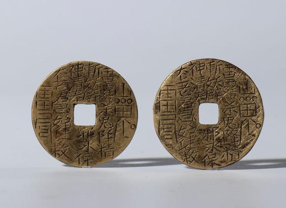 Bertolami Fine ArtLot comprising a silver-plated metal gyroscope sphere, two hand-engraved Kangxi Tongbao coins, and a copper alloy vajra. China, 20th century.