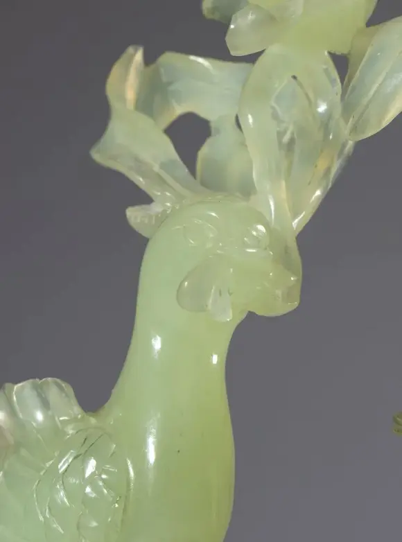 Bertolami Fine ArtGreen jade sculpture on a wooden base depicting a pair of birds and a large flower. China, 20th century.