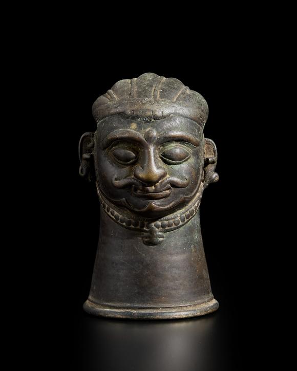 RoseberysA small brass Shiva lingam cover,?
Western Deccan, 19th century,?

with almond bulging eyes under marked eyebrows, his full lips under a serpenti
