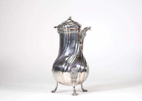 Goldfield Auction sarlsGrande chocolatière en argent massif reposant sur trois pieds cambrés, à décor de c?tes torses et appliques rocaille, bec verseur feuillagé, couvercle