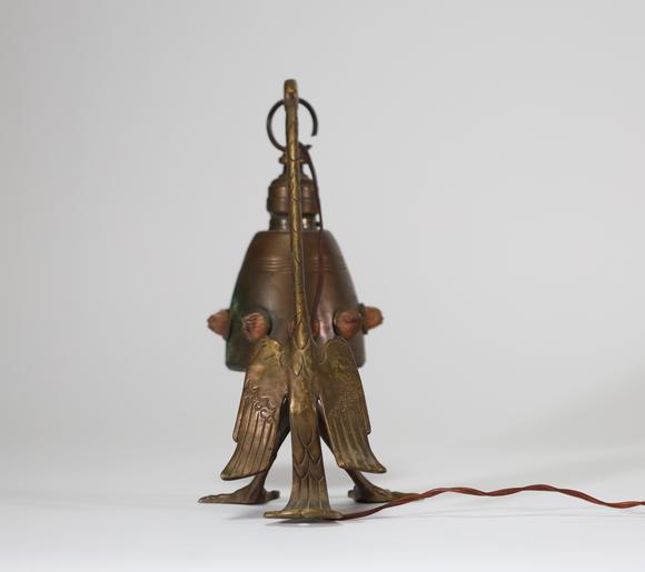 Goldfield Auction sarlsLampe de table Art déco en métal patiné figurant un échassier stylisé soutenant une bobèche suspendue, ornée de cabochons en relief. Travail des année
