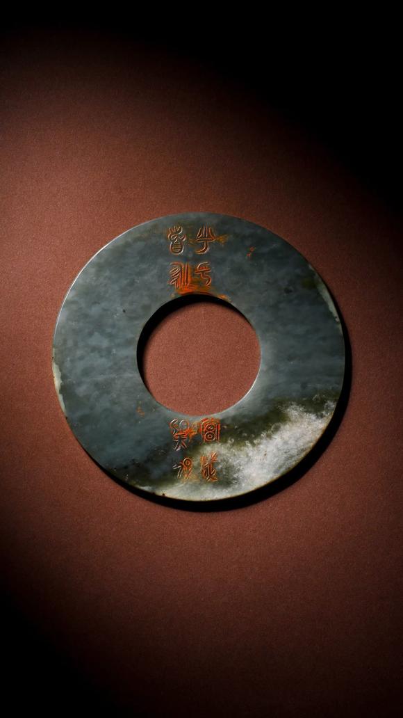 HUNG YUN ZHAI AUCTION HOUSE INCPre-Ming Dynasty Cinnabar-Infiltrated Dragon- Pattern Jade Bi Disc