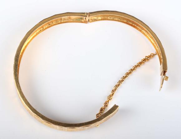 TooveysA gold circular hinged bangle with facet cut decoration, detailed ‘