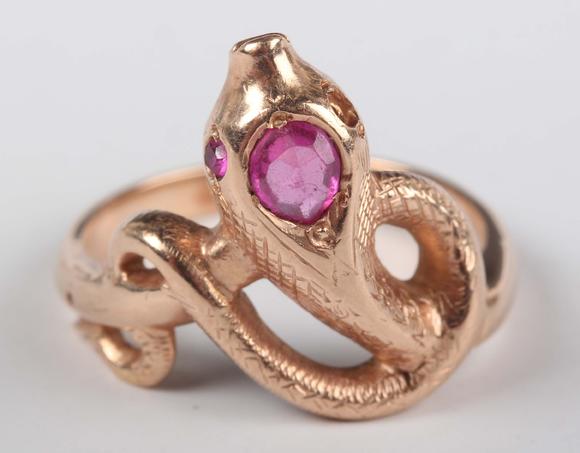 TooveysA gold, ruby and synthetic ruby ring, designed as a coiled snake, de