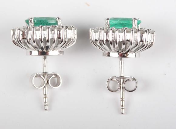 TooveysA pair of white gold, emerald and diamond oval cluster earstuds, eac
