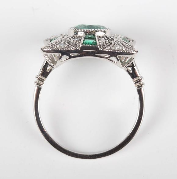TooveysA platinum, emerald and diamond panel ring in an Art Deco inspired d
