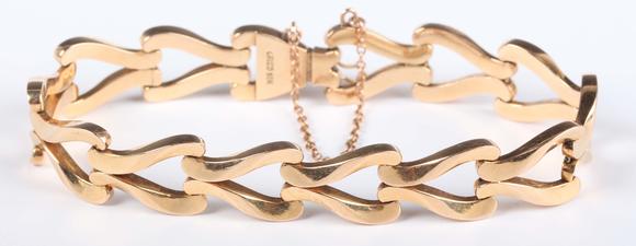 TooveysA gold bracelet in a twin scroll openwork link design, on a snap cla