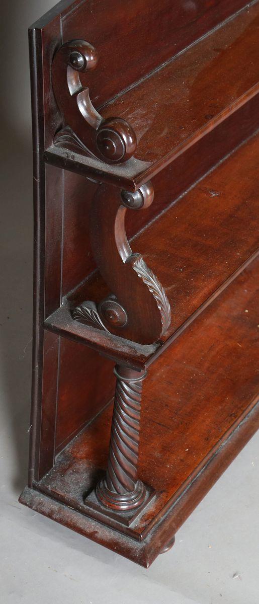 TooveysAn early Victorian mahogany three-tier graduated bookshelf with scro