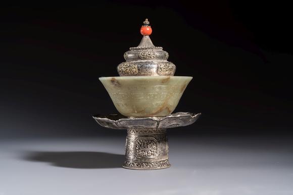 Rob Michiels AuctionsA Tibetan ritual jade bowl with a red coral-mounted silver cover and a stand, 19th C.
