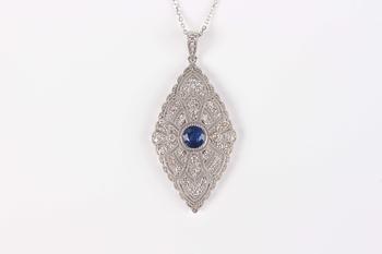 A platinum, treated sapphire and diamond marquise shaped pendant, collet set with the circular cut sapphire at the centre, length 4.3cm, with a platin