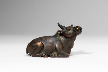 Ming Dynasty, Ca. AD 1368 - 1644, or earlier. >
A cast bronze figure of a recumbent bull, depicte