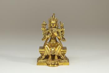 Travail sino-tibétain, XVIIe siècle sculpture en bronze doré représentant une divinité bouddhique assise en vajrāsana sur un socle lotiforme, les main