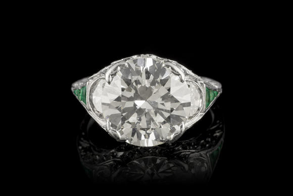 Piguet - H?tel des VentesBague Art Déco platine centrant un diamant taille brillant entouré de diamants taille demi-lune et 8/8 ainsi que d'émeraudes calibrées<br><br><i>Art Déco platinum ring set with one center diamond, half-moon and 8/8 cut diamonds and calibrated-cut emeralds</i>