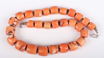 A single row necklace of graduated barrel form dyed coral beads, Nor