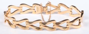 A gold bracelet in a twin scroll openwork link design, on a snap cla