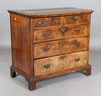 A George I walnut chest of oak-lined drawers with feather banded bor