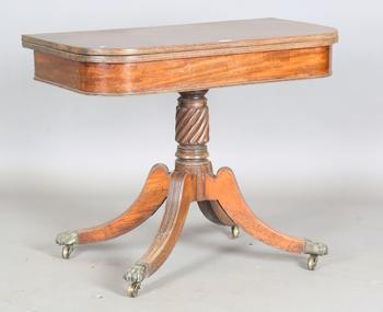 A Regency mahogany fold-over tea table, raised on a spiral reeded st