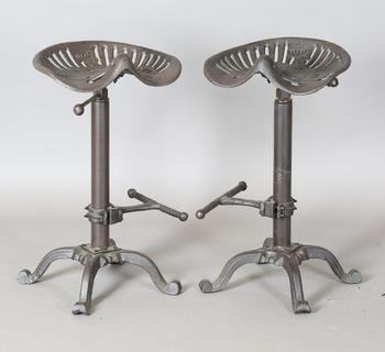 A pair of late 20th century cast iron bar stools with reproduction J
